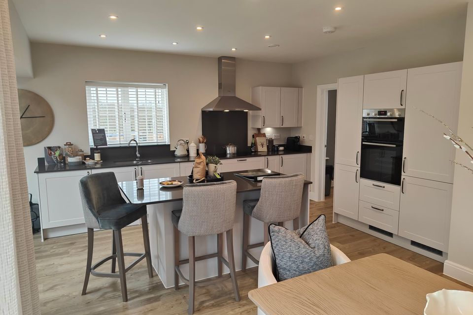 Light kitchen interior with a central island and upholstered seating.