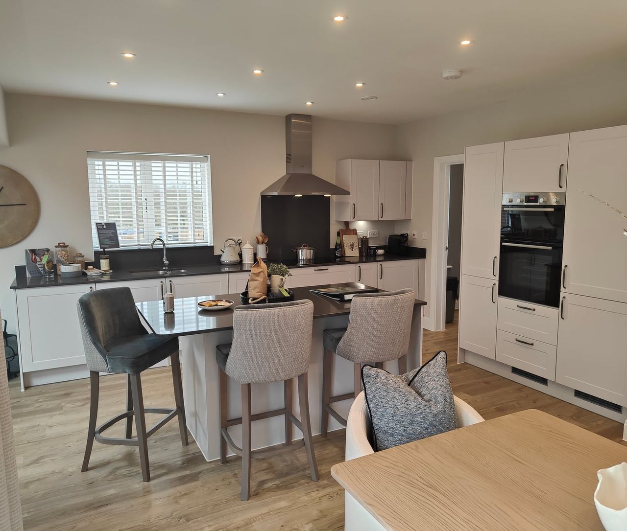 Light kitchen interior with a central island and upholstered seating.
